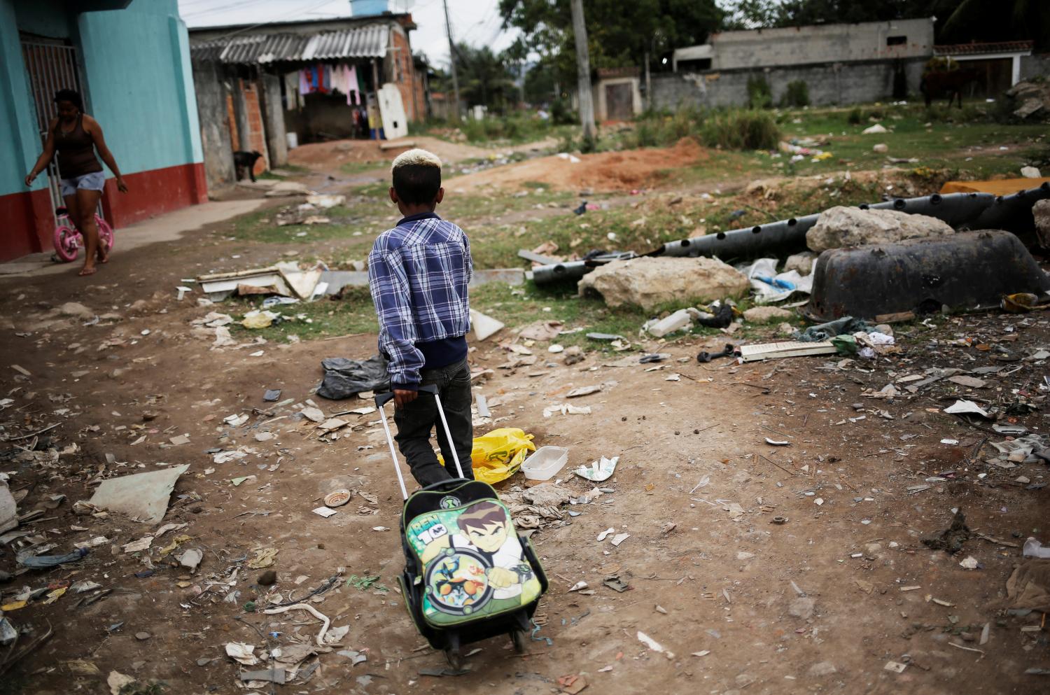 A boy pulls his school bag at a favela, or a slum, in Rio de Janeiro