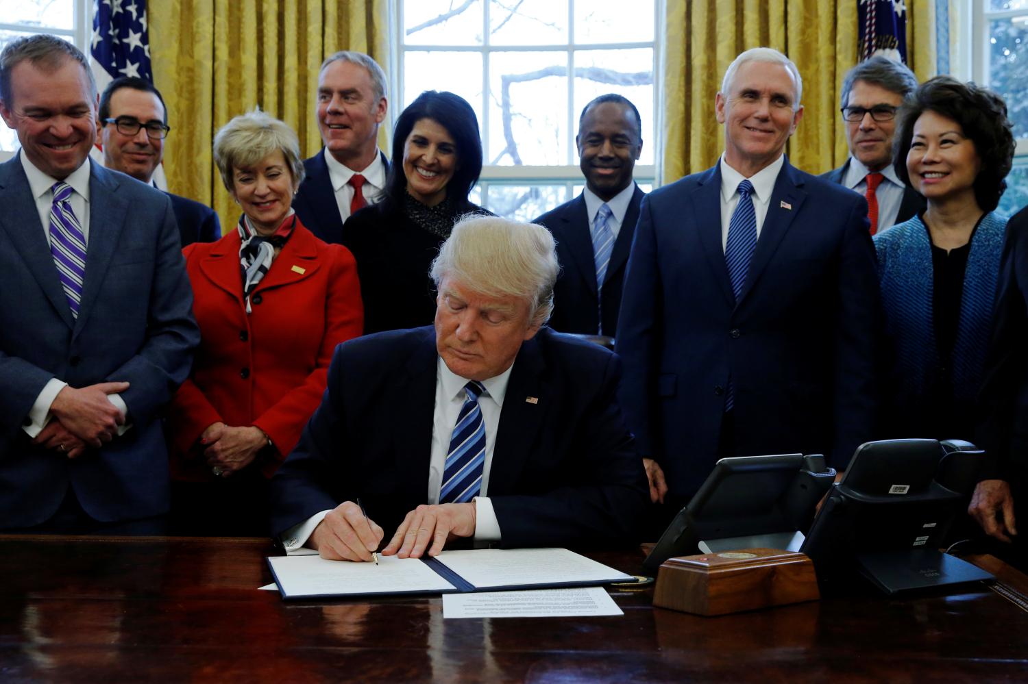 Trump signs an executive order in the Oval Office at the White House in Washington