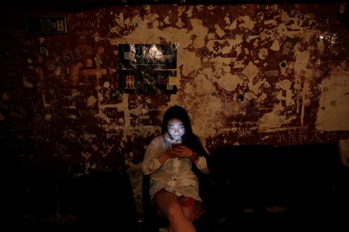 A girl uses her phone at Mao Live House during its last public concert night in central Beijing, China April 24, 2016. Mao Live House, a prominent live rock music venue in Beijing, shut its doors on the weekend, the latest closure to hit China's rock music scene. Owner Li Chi said the club, popular among fans of punk, metal and alternative rock since it opened nine years ago, was forced to close due to tighter rules on live performances. REUTERS/Damir Sagolj      SEARCH "MAO LIVE" FOR THIS STORY. SEARCH "THE WIDER IMAGE" FOR ALL STORIES  - S1BETBXEYAAB