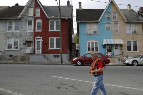A man walks past multi-colored homes that face the now-closed Bethlehem Steel mill in Bethlehem, Pennsylvania, U.S. April 22, 2016. After Bethlehem Steel's blast furnaces went silent 20 years ago in the city of Bethlehem, Pennsylvania, the local economy bounced back as new industrial parks filled with e-commerce companies and white-collar businesses fleeing New York's higher costs. That adds to the challenge for Donald Trump, Republican nominee for the U.S. presidency, as he seeks voters' backing in the state's primary on April 26. REUTERS/Brian Snyder    SEARCH "BETHLEHEM STEEL" FOR THIS STORY. SEARCH "THE WIDER IMAGE" FOR ALL STORIES - GF10000393653