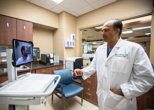 Dr. Ravi Madasu, an emergency medicine specialist at Baptist Memorial Health Care hospital, uses a a mobile computer cart to  speak with Dr. Shawn Hamm, Board-certified addiction medicine specialist on-screen Monday, Sept. 25, 2019.Baptist Er Addiction Cases