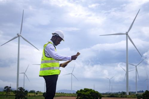 African engineer standing with wind turbines