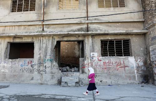 A girl walks near a building destroyed during past fighting with Islamic State militants, in the old city of Mosul, Iraq February 1, 2022. REUTERS/Khalid al-Mousily