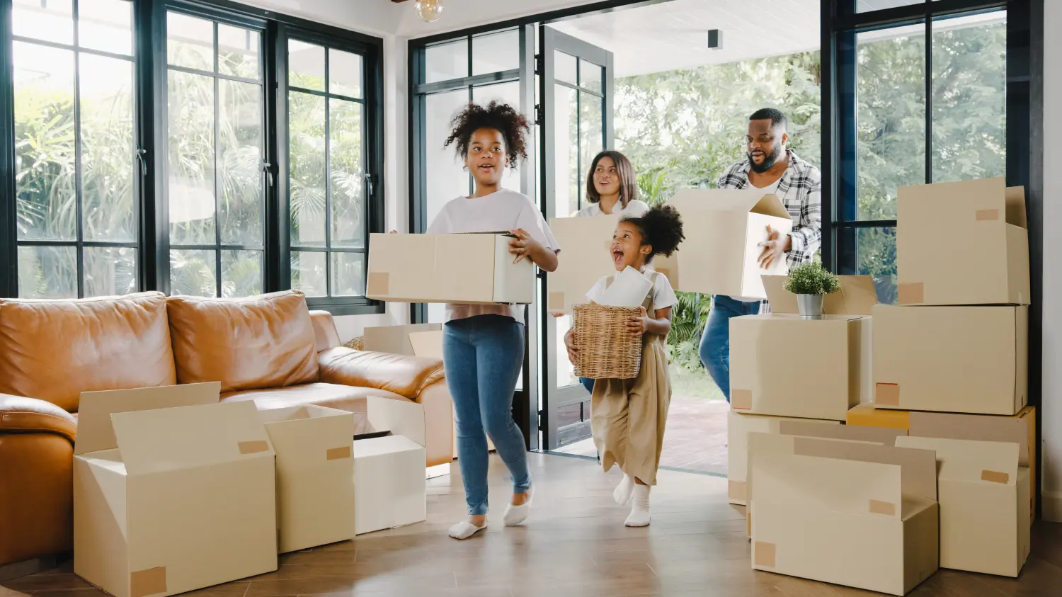 Happy Black family moving into new house filled with boxes