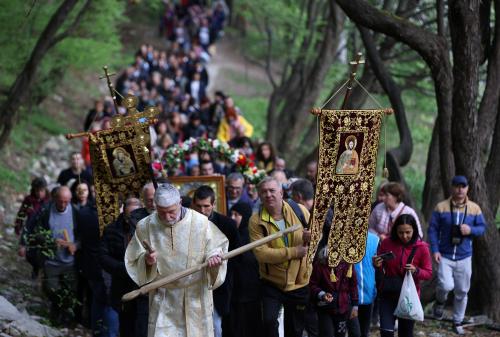 An Orthodox Christian priest walks in front of worshippers, as they carry an icon of Virgin Mary during a parade marking Easter near Bachkovo monastery, Bulgaria, April 25, 2022. REUTERS/Stoyan Nenov