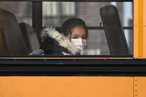 A student on a school bus wears a mask as she arrives at P.S. 7 Louis F. Simeone as the masks policy for K through 12 is lifted, Queens, New York, NY, March 7, 2022. Credit: Anthony Behar/Sipa.