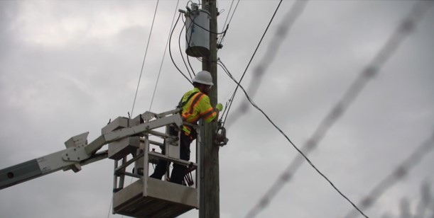 Lineman hanging fiber cables in Macon County, Alabama