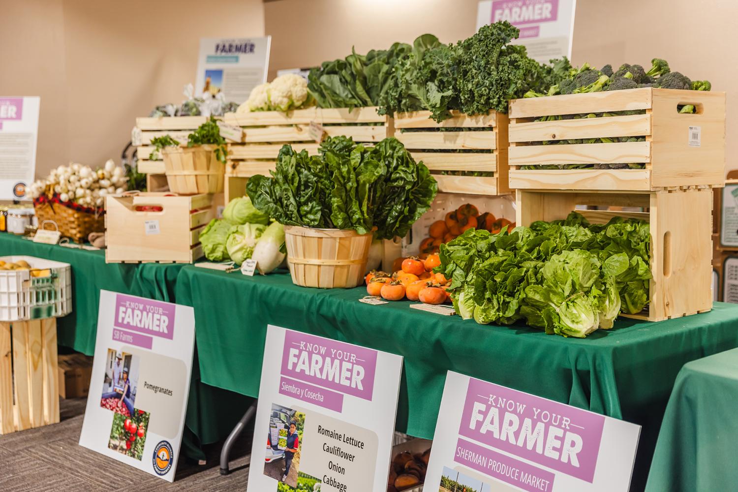 Leafy produce on a table with "Know your farmer" signs