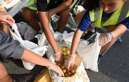 Volunteers place potatoes into small bags at a food distribution event for the needy sponsored by the Second Harvest Food Bank of Central Florida and Orange County at St. John Vianney Church in Orlando, Florida. High food and gas prices are squeezing working families, sending some to food pantries for the first time, but providers are struggling with inflation costs as demand spikes.