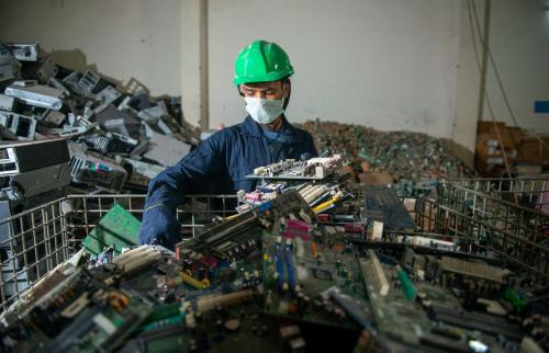 Uttarakhand, India, January 29 2021 : worker with Discarded or obsolete spare PC parts and accessories such as mainboards, colored cables and connectors, Electronic waste recycling plant at haridwar
