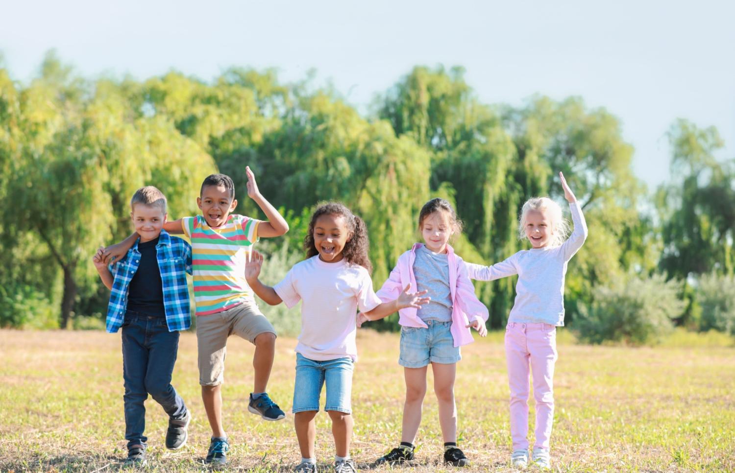 a group of cheerful small children in a sunny field