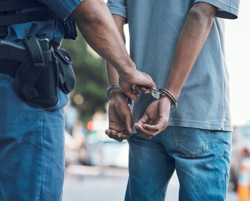 Police with man in handcuffs