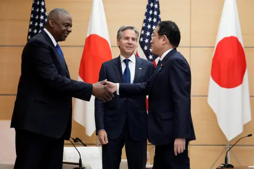 U.S. Secretary of State Antony Blinken looks at Japanese Prime Minister Fumio Kishida shake hands with U.S. Defense Secretary Lloyd Austin as they meet at the prime minister's office in Tokyo, Japan, July 29, 2024.