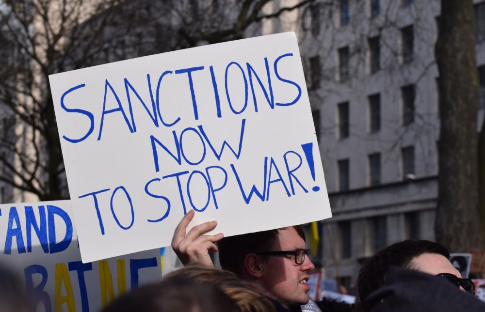 Protesters holding a sign about sanctions