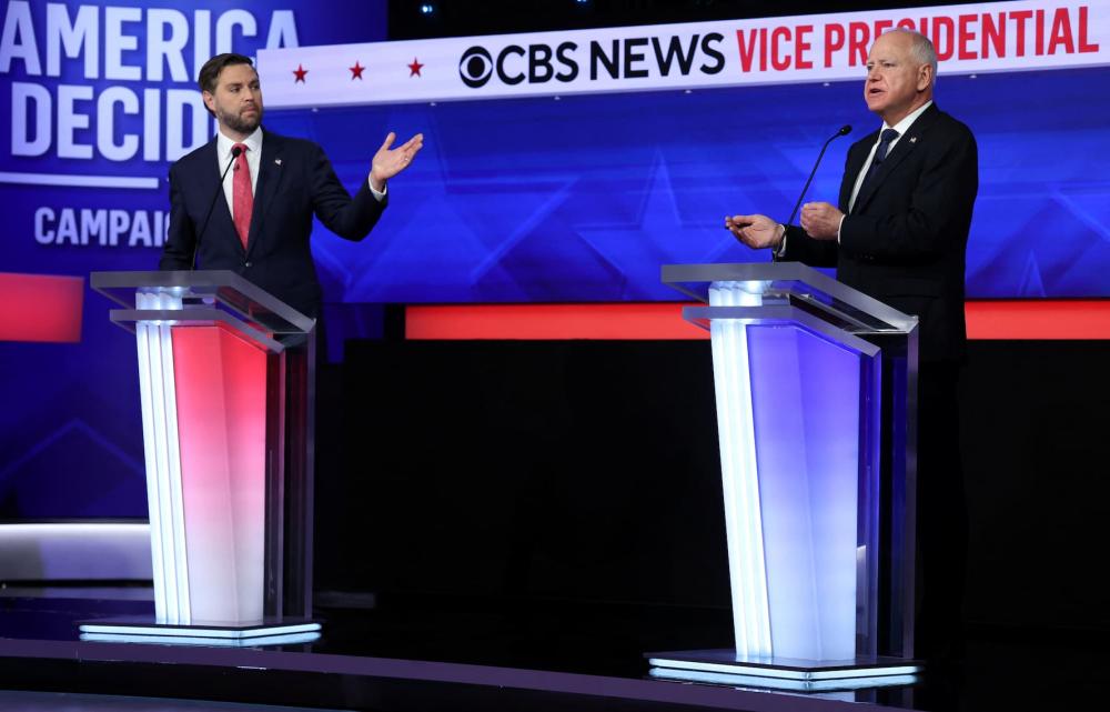 Republican vice presidential nominee U.S. Senator JD Vance (R-OH) gestures towards Democratic vice presidential nominee Minnesota Governor Tim Walz as Walz speaks during a debate hosted by CBS in New York, U.S., October 1, 2024.